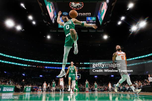Jayson Tatum of the Boston Celtics dunks past Jalen Brunson of the New York Knicks during the second quarter at TD Garden on December 8, 2023 in...