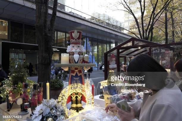 Shoppers browse at pop-up stores along a street decorated with Christmas lights in the Marunouchi area of Tokyo, Japan, on Friday, Japan, on Dec. 8,...