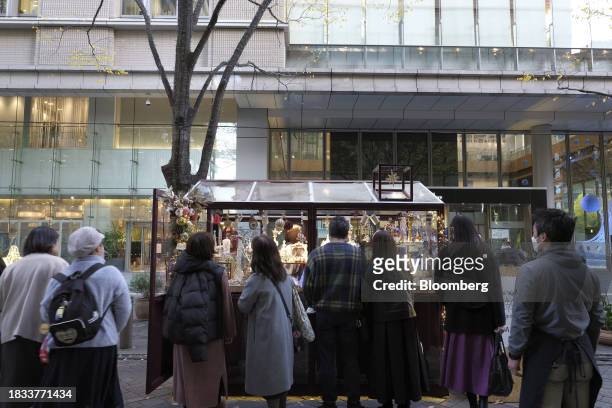 Shoppers browse at pop-up stores along a street decorated with Christmas lights in the Marunouchi area of Tokyo, Japan, on Friday, Japan, on Dec. 8,...
