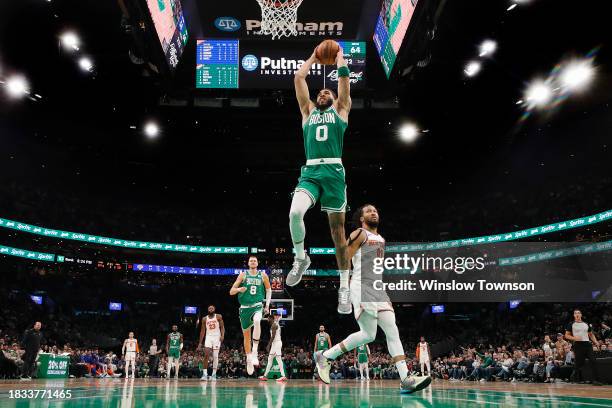 Jayson Tatum of the Boston Celtics goes in for a dunk past Jalen Brunson of the New York Knicks during the second quarter at TD Garden on December 8,...