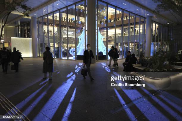 Pedestrians walk past a Christmas tree in the Marunouchi area of Tokyo, Japan, on Friday, Japan, on Dec. 8, 2023. Inflation data are well above the...