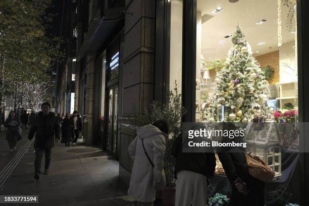 People walk along the street decorated with Christmas lights in the Marunouchi area of Tokyo, Japan, on Friday, Japan, on Dec. 8, 2023. Inflation...