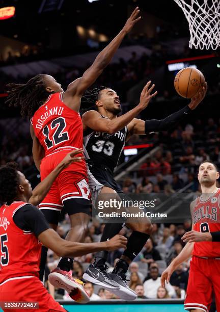 Tre Jones of the San Antonio Spurs drives past Ayo Dosunmu of the Chicago Bulls in the first half at Frost Bank Center on December 08 2023 in San...