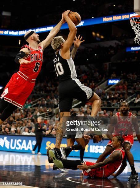 Alex Caruso of the Chicago Bulls blocks shot of Jeremy Sochan of the San Antonio Spurs in the first half at Frost Bank Center on December 08 2023 in...