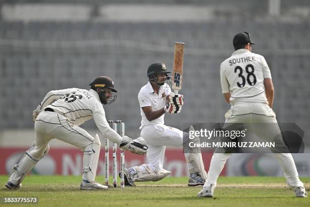 Bangladesh's Taijul Islam plays a shot as New Zealand's captain Tim Southee and his teammate Tom Blundell watches during the fourth day of the second...