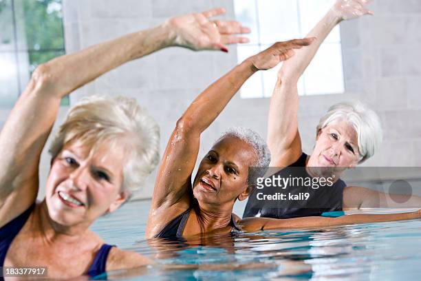 multiracial senior women in water aerobics class - aquarobics stockfoto's en -beelden