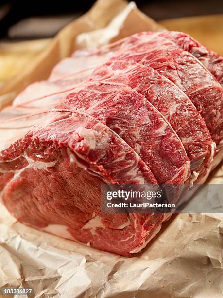 rôti de bœuf cru en papier de boucherie - rosbif photos et images de collection