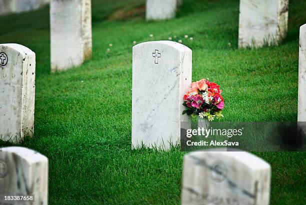 tombstone with flowers - funeral flowers stockfoto's en -beelden