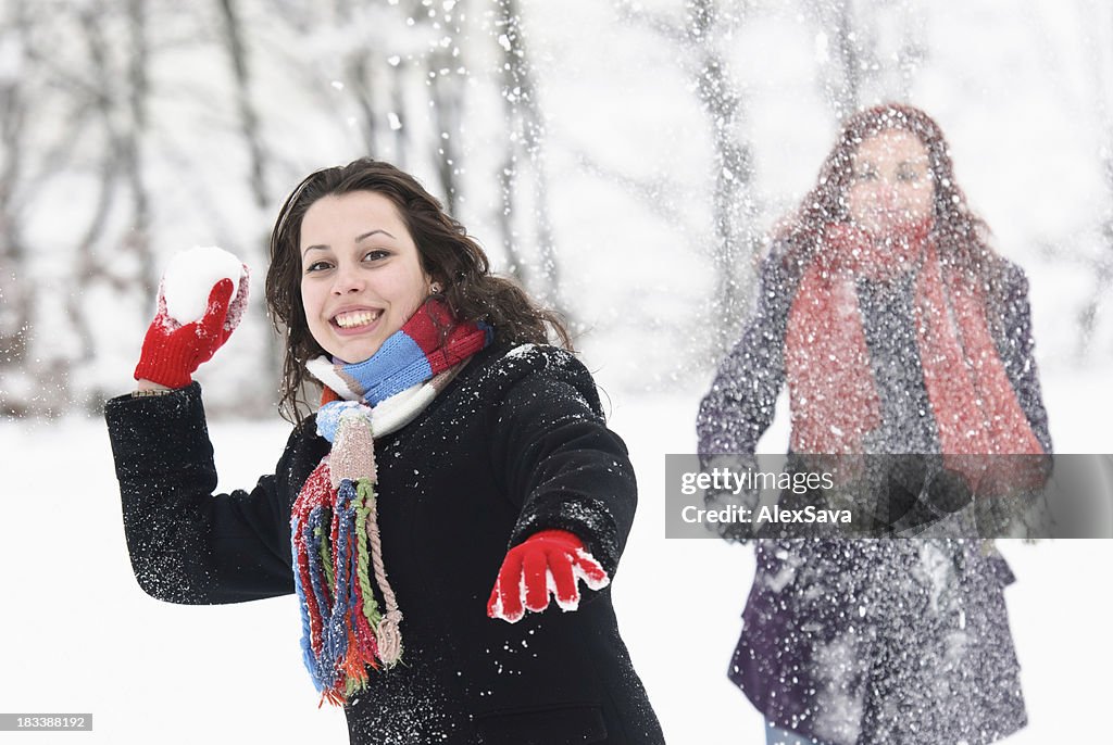 Junge Frau trowing ein Schneeball in Richtung Kamera