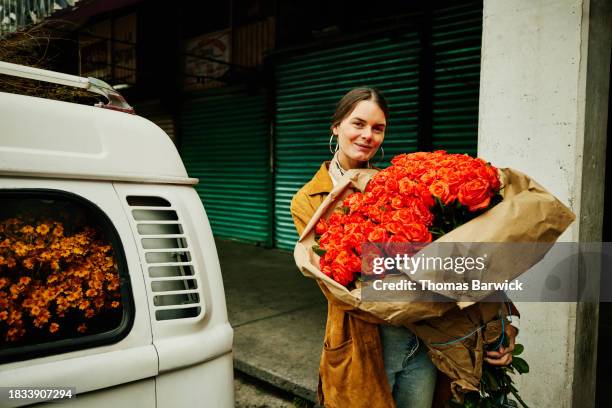 medium wide shot portrait smiling woman holding large bouquet of roses - giant roses stock pictures, royalty-free photos & images