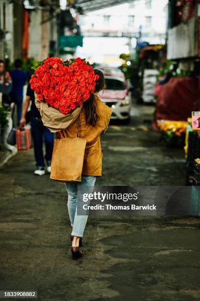 wide shot woman carrying heart shaped bouquet of roses over shoulder - flowers placed on the hollywood walk of fame star of jay thomas stockfoto's en -beelden
