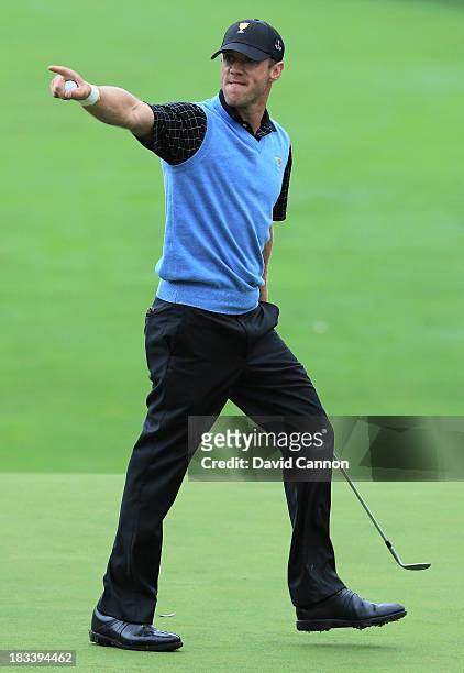 Graham DeLaet of Canada and the International Team reacts to holing a pitch shot for birdie on the 18th hole during the weather-delayed Day Three...