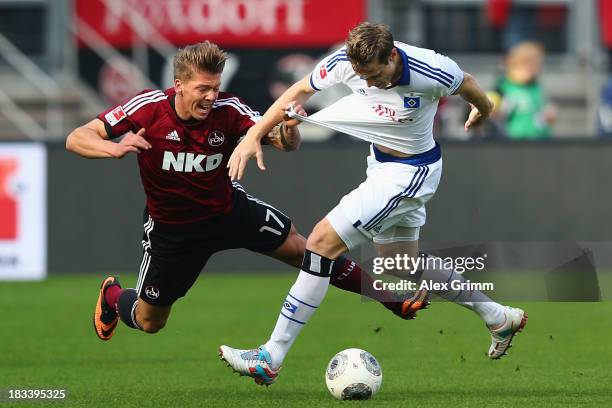 Mike Frantz of Nuernberg is challenged by Marcell Jansen of Hamburg during the Bundesliga match between 1. FC Nuernberg and Hamburger SV at Grundig...