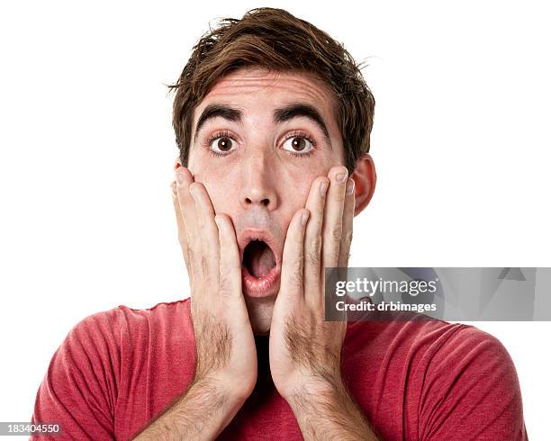 shocked young man with hands on cheeks - man fear stock pictures, royalty-free photos & images