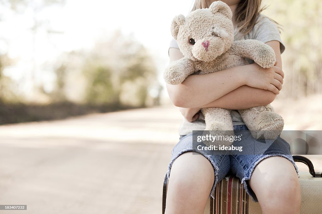 Allein junge Mädchen umarmen Teddybär, Raggedy alten