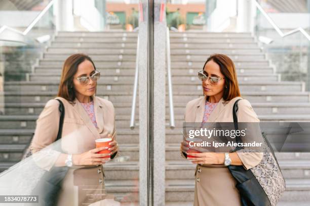 businesswoman reflected in store window access to subway - same person different looks stock pictures, royalty-free photos & images