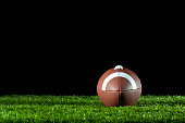 Gridiron ball on the grass at night.
