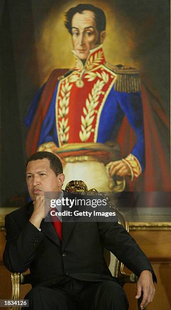 Venezuelan President Hugo Chavez sits under a painting of the country's liberator Simon Bolivar before swearing in a new board of directors for state...
