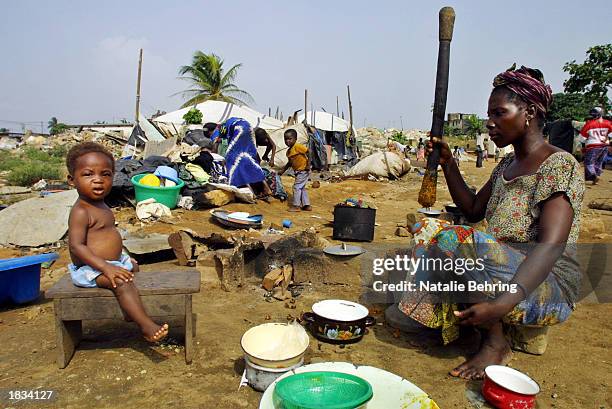 An Ivorian mother prepares dinner in a demolished shanty town March 7, 2003 in the capital city Abidjan, Ivory Coast. There were 131 shanty towns,...