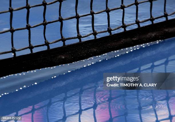 Raindrops come off the net on the court in Arthur Ashe Stadium as play was suspended at the 2006 US Open at the USTA National Tennis Center in New...