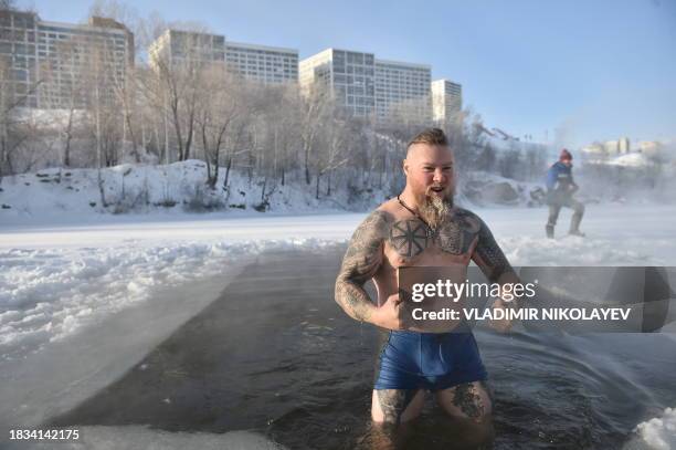 Winter swimming enthusiast gets out of an ice hole after taking a swim at a lake in the Siberian city of Novosibirsk with the air temperature at...