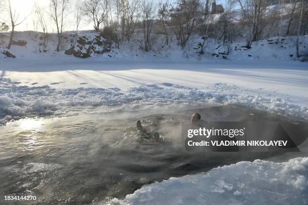 Winter swimming enthusiast swims in an ice hole at a lake in the Siberian city of Novosibirsk with the air temperature at around minus 35 degrees...