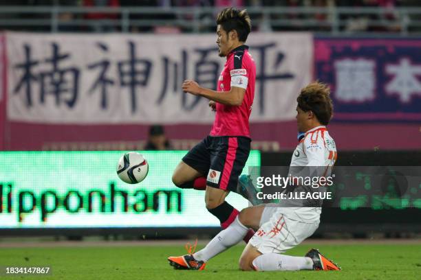 Hotaru Yamaguchi of Cerezo Osaka is tackled by Makoto Rindo of Ehime FC during the J.League J1 Promotion Play-Off semi-final between Cerezo Osaka and...