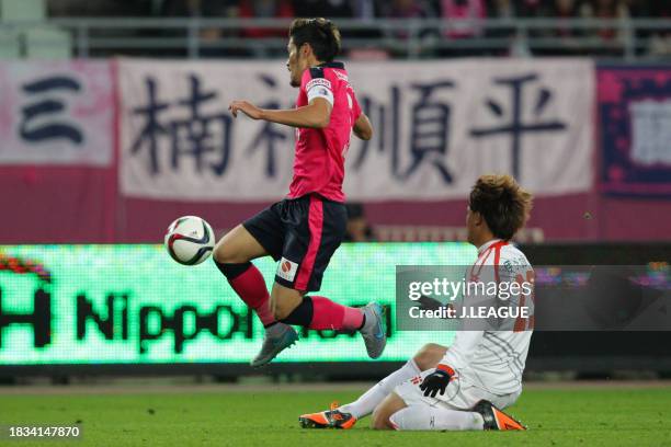 Hotaru Yamaguchi of Cerezo Osaka is tackled by Makoto Rindo of Ehime FC during the J.League J1 Promotion Play-Off semi-final between Cerezo Osaka and...