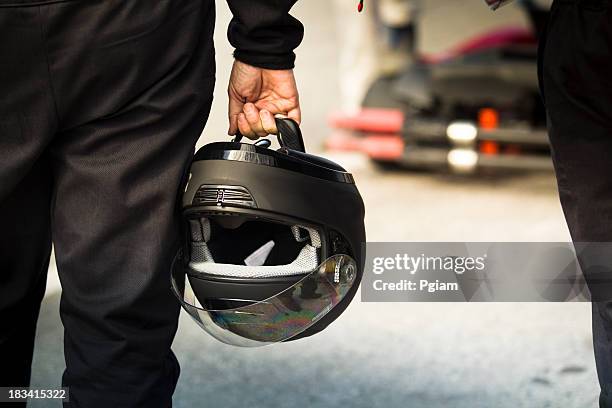 race driver holds a helmet on the track - helmet stock pictures, royalty-free photos & images