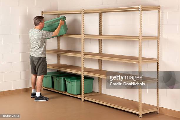 man placing bin on shelf - cellar stockfoto's en -beelden