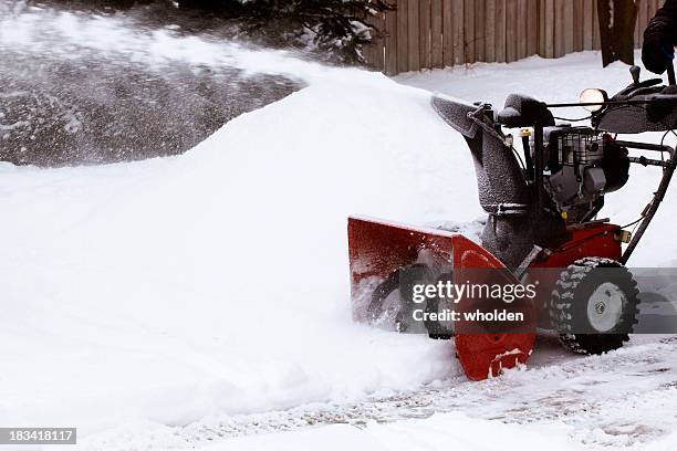 close-up of red snowblower clearing snow-filled lane - sneeuwmachine stockfoto's en -beelden