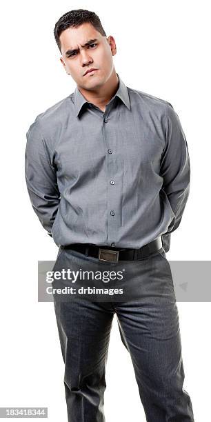 frowning young man standing - grijze broek stockfoto's en -beelden