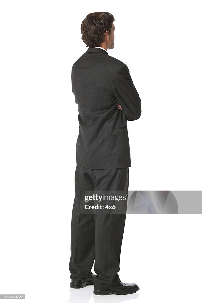 Rear view of isolated businessman arms folded