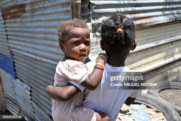 This photograph taken on December 8 shows residents in the Mavadzani shantytown, on the heights of Koungou, on the French Indian Ocean island of...