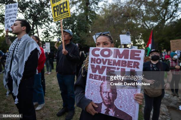 Woman holds a sign suggesting that she might now vote for Donald Trump for president as protesters denounce the Biden administration's support of...