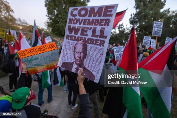 Woman holds a sign suggesting that she might now vote for Donald Trump for president as protesters denounce the Biden administration's support of...