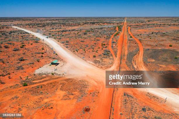outback state border road and dingo  fence - dingo fence stockfoto's en -beelden