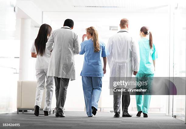 doctors and nurses are walking together. view from behind. - doctor behind stock pictures, royalty-free photos & images