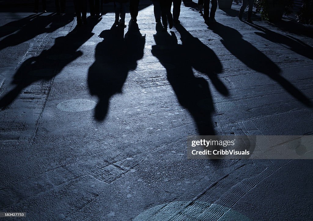 Gang of people advancing on viewer night shadows