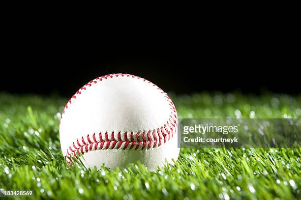 baseball in the grass at night - softball sport stock pictures, royalty-free photos & images