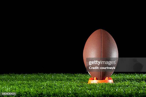 gridiron ball standing on a tee - american football lineman stockfoto's en -beelden