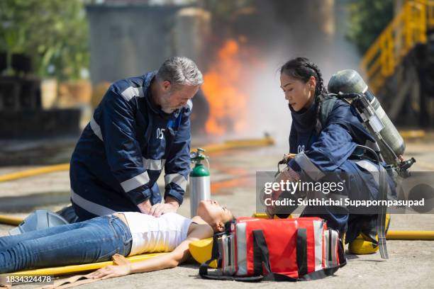 emergency response: firefighter providing cpr to save a life in fire incident - fire extinguisher inspection stock pictures, royalty-free photos & images