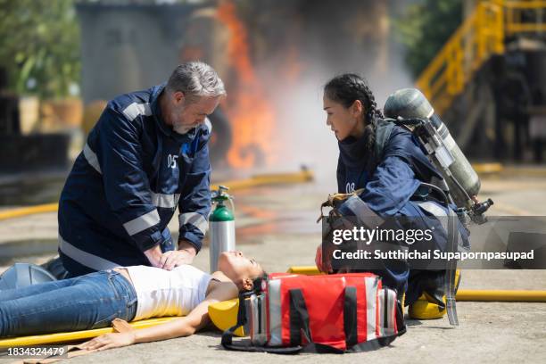 emergency response: firefighter providing cpr to save a life in fire incident - fire extinguisher inspection stock pictures, royalty-free photos & images