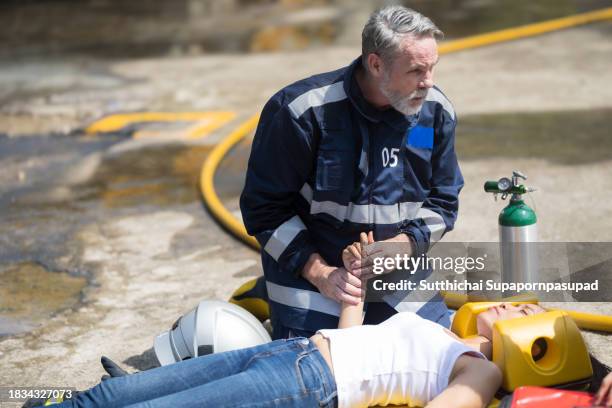 emergency response: firefighter providing cpr to save a life in fire incident - fire extinguisher inspection stock pictures, royalty-free photos & images