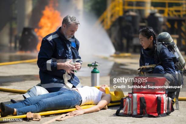 emergency response: firefighter providing cpr to save a life in fire incident - fire extinguisher inspection stock pictures, royalty-free photos & images