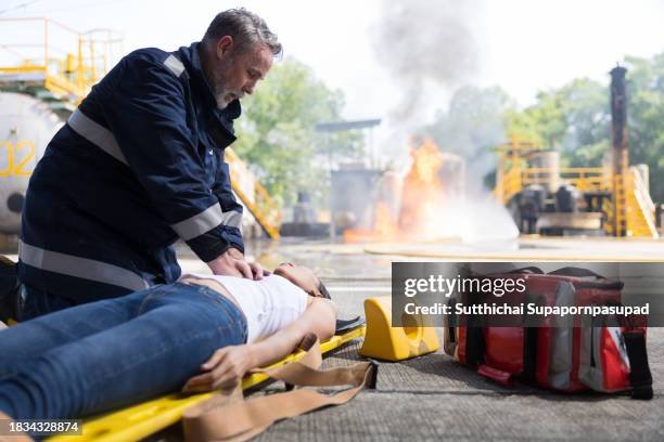 emergency response: firefighter providing cpr to save a life in fire incident - fire extinguisher inspection stock pictures, royalty-free photos & images