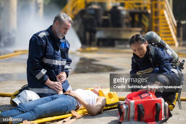 emergency response: firefighter providing cpr to save a life in fire incident - fire extinguisher inspection stock pictures, royalty-free photos & images