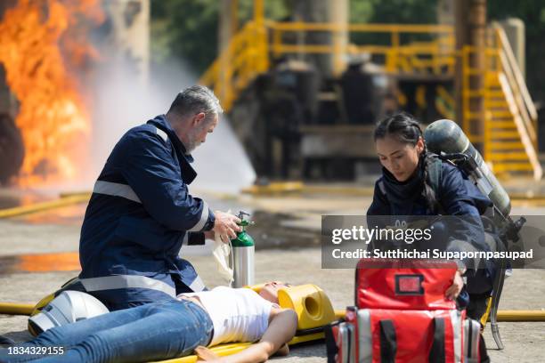 emergency response: firefighter providing cpr to save a life in fire incident - fire extinguisher inspection stock pictures, royalty-free photos & images