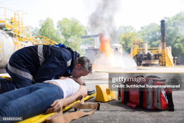 emergency response: firefighter providing cpr to save a life in fire incident - fire extinguisher inspection stock pictures, royalty-free photos & images