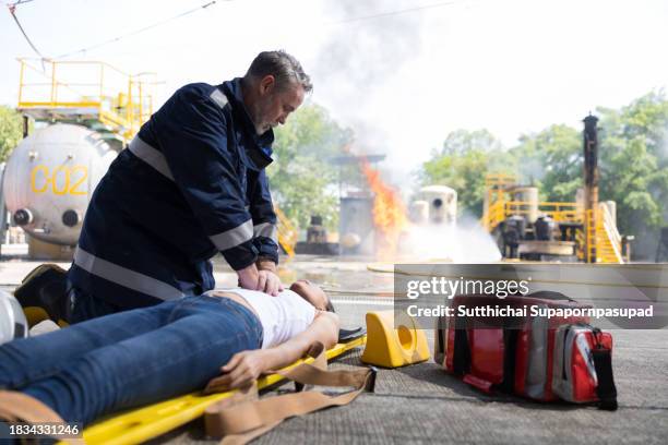 emergency response: firefighter providing cpr to save a life in fire incident - fire extinguisher inspection stock pictures, royalty-free photos & images